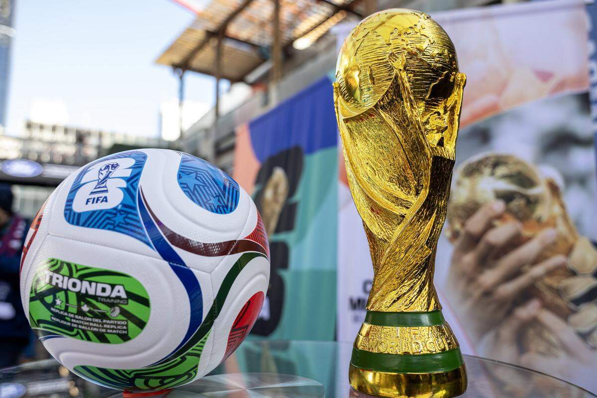 A replica of the FIFA World Cup trophy is displayed alongside a soccer ball during the FIFA World Cup draw watch party at the Power & Light District on Friday, Dec. 5, 2025, in Kansas City.
