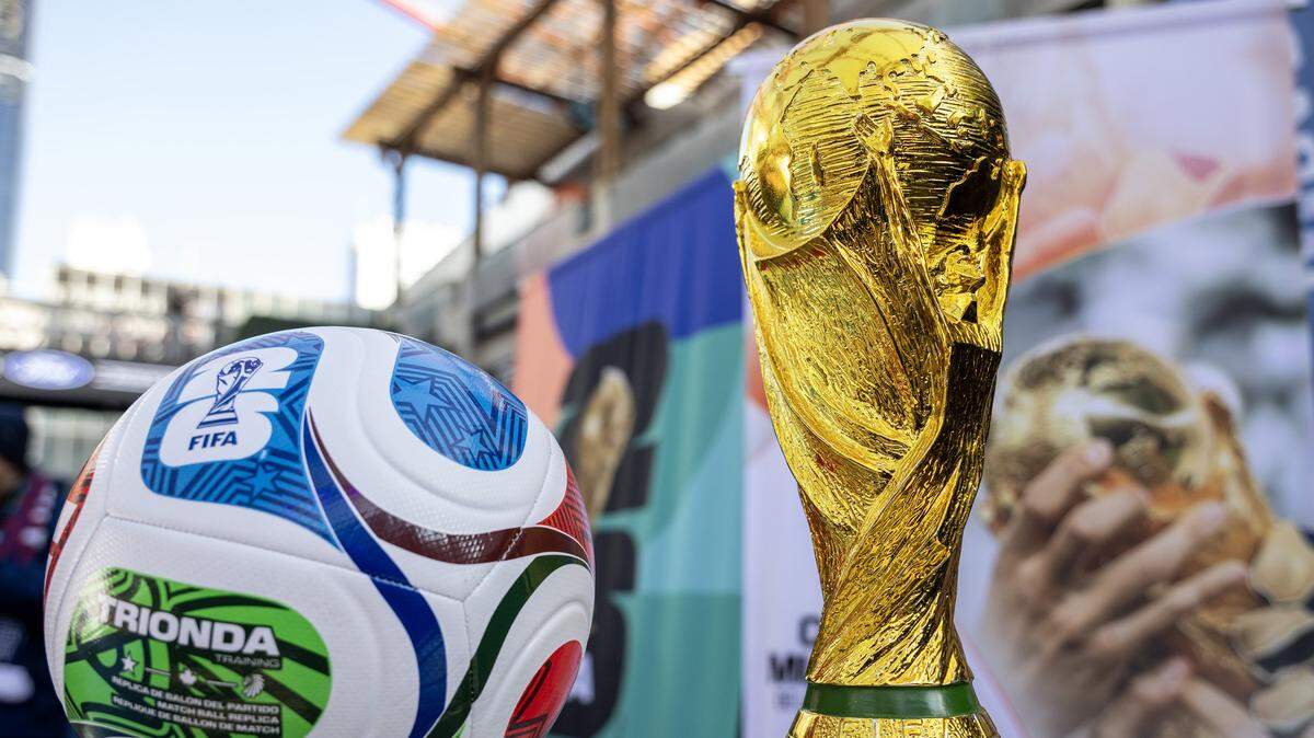 A replica of the FIFA World Cup trophy is displayed alongside a soccer ball during the FIFA World Cup draw watch party at the Power & Light District on Friday, Dec. 5, 2025, in Kansas City.