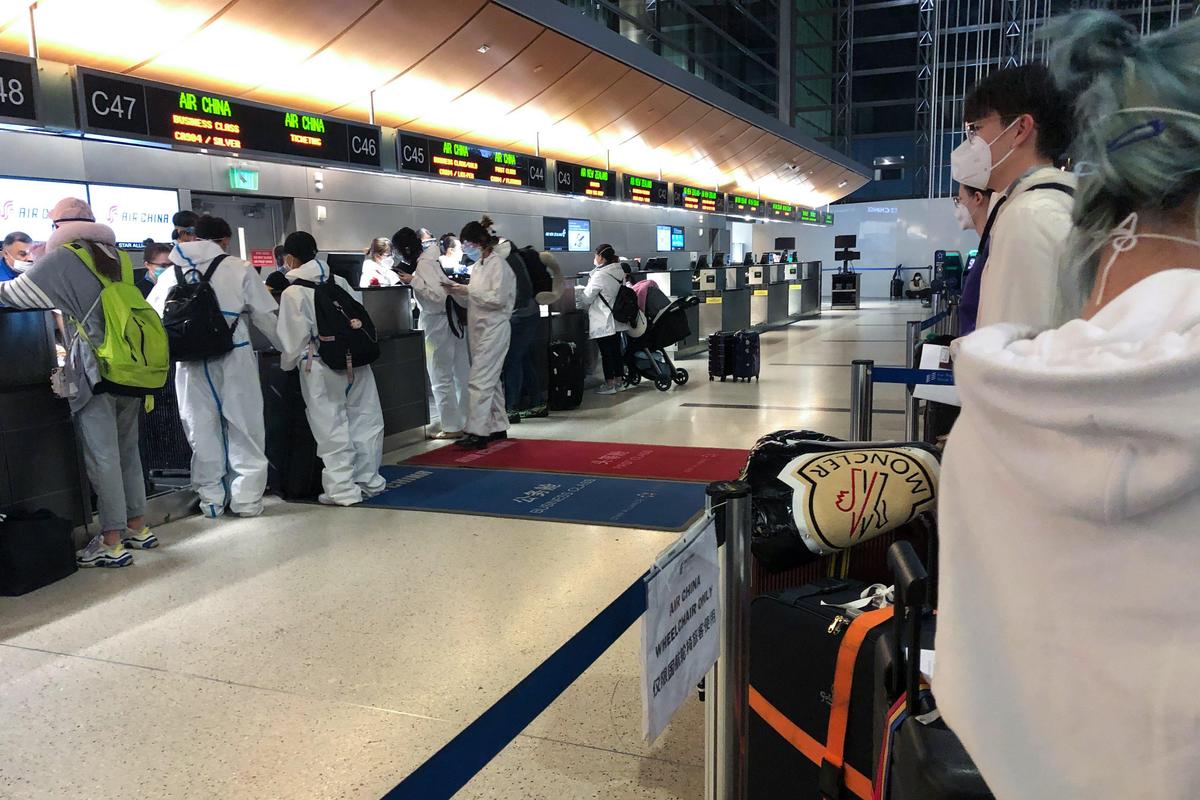 International travelers wait to check in at the Los Angeles International Airport on March 27. Many wore protective gear from head to toe, a combination of laboratory goggles, face masks, gloves, hazmat suits and even shoe covers.