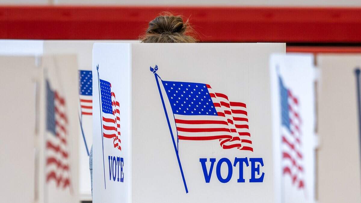 A sliver of hair sticks out from a voting booth as a voter casts their ballot at Van Horn High School during Election Day on Tuesday, April 7, 2026, in Independence.
