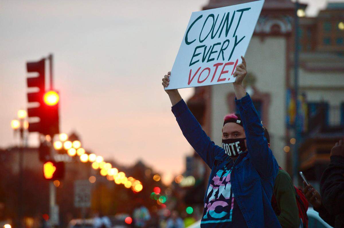 Jae Moyer, 21, of Overland Park, chants “count every vote” as part of an election rally on Wednesday, Nov. 4, 2020, at the intersection of Mill Creek Parkway and Emanuel Cleaver II Boulevard.