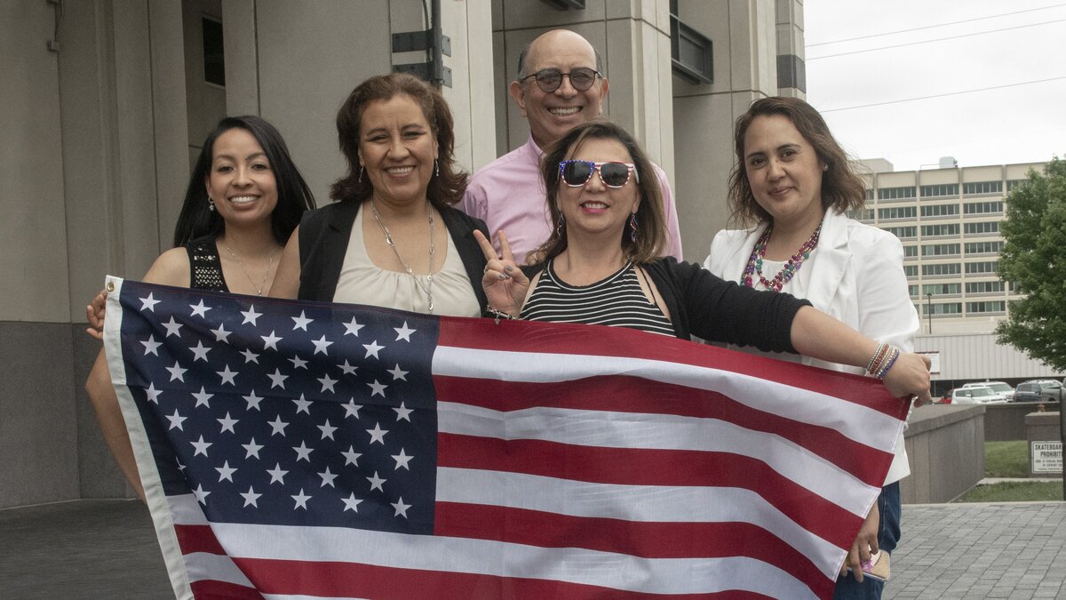 Dora Forero (wearing sunglasses), who came to the United States from Mexico, registered to vote Friday after becoming a U.S. citizen. Afterward, she posed with family and friends outside the Robert J. Dole Federal Courthouse in Kansas City, Kan.