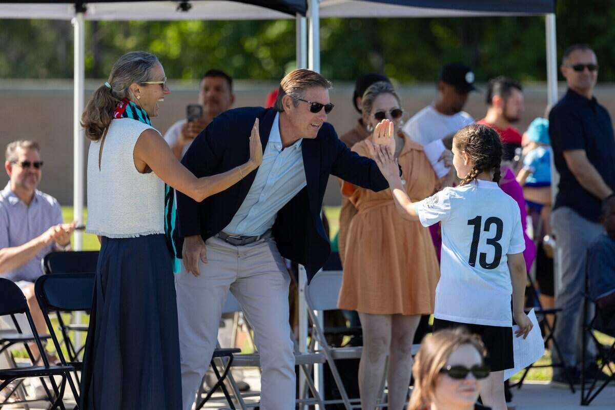 Youth from Estrella De Oro high-fives Co-Founders and Co-Owners of the Kansas City Current Angie and Chris Long during the opening ceremony of the Kansas City Current's No-Cost, No-Barrier Soccer League at 901 Van Brunt Blvd on Saturday, July 11, 2026. The league, presented by CVS Health, aims to increase youth soccer participation, particularly among girls, while providing education for coaches and referees.