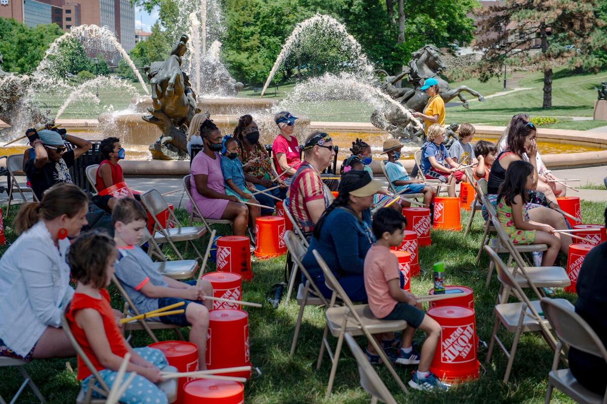 As part of Make Music Kansas City, participants tap on buckets during the Urban Bucket Brigade Workshop at Mill Creek Park, Monday, June 21, 2021 in Kansas City. Jaisson Taylor led the workshop teaching rhythms to the group as Kansas City made its’ debut on Make Music Day, a world-wide celebration of music happening in over 1,000 cities in 120 countries. Over 70 free musical events were held city-wide as part of the event.