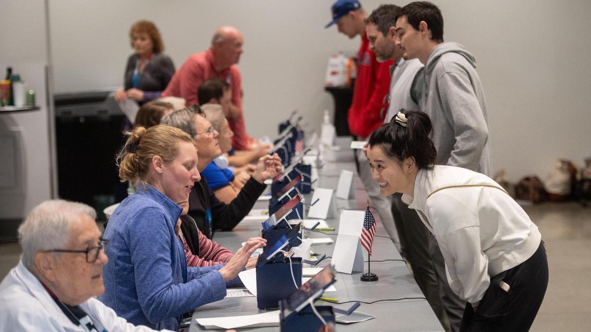 An election worker helps sign in a voter on Election Day at the Johnson County Arts and Heritage Center in Overland Park on Tuesday, Nov. 5, 2024.
