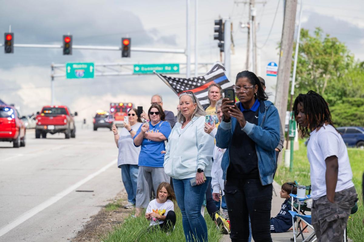 Bystanders watch as a section of the funeral procession for fallen KCFD firefighter Grant Hoffman goes down Bannister Road in Kansas City on Friday, May 2, 2025.
