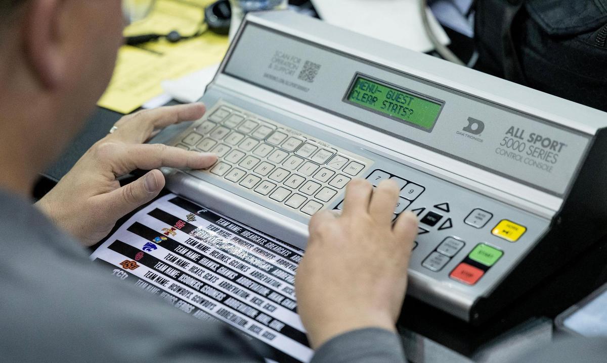 Looking like some kind of old-school word processor, the score clock operator uses the scoreboard control to set the scoreboard before the start of the Kansas Jayhawks and Cincinnati Bearcats game during the Big 12 men’s basketball tournament on Wednesday.