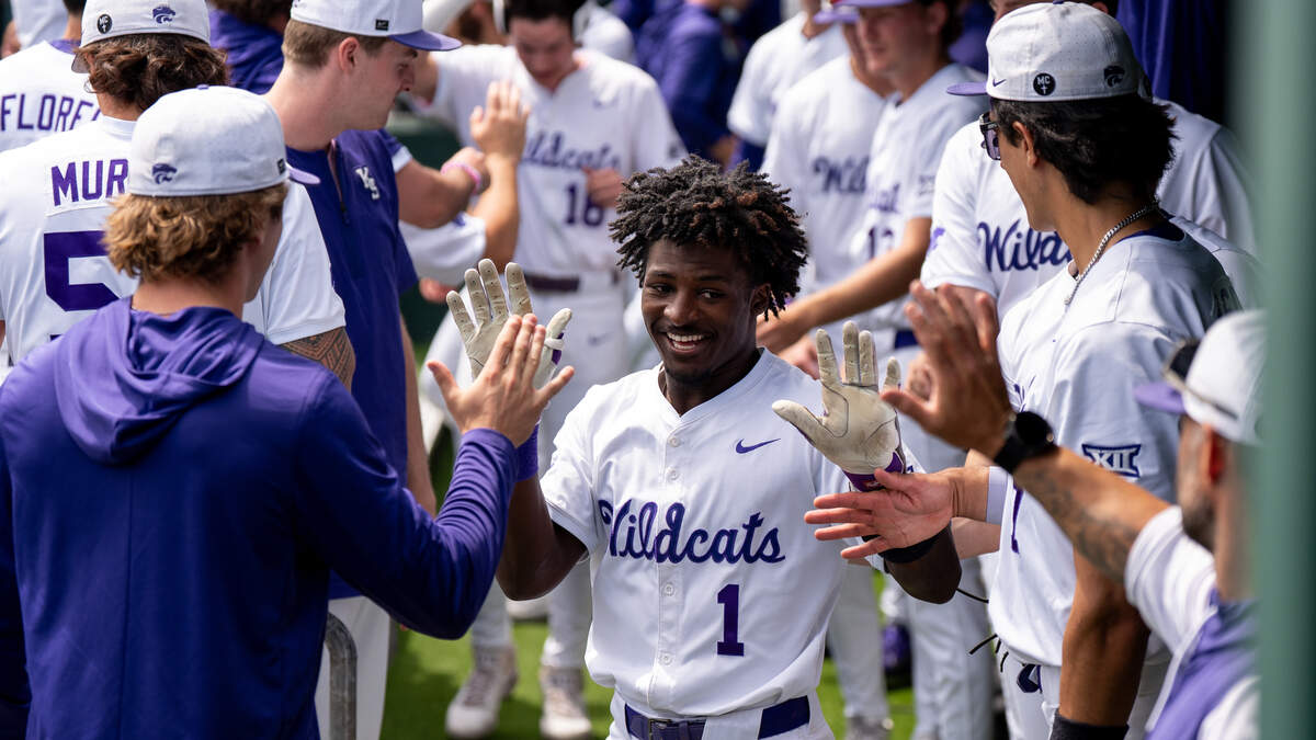 Kansas State Wildcats baseball player Dondreone “Dee” Kennedy high-fives teammates during the 2026 season. Kennedy is an MLB Draft hopeful after transferring from Texas to K-State — and thriving.