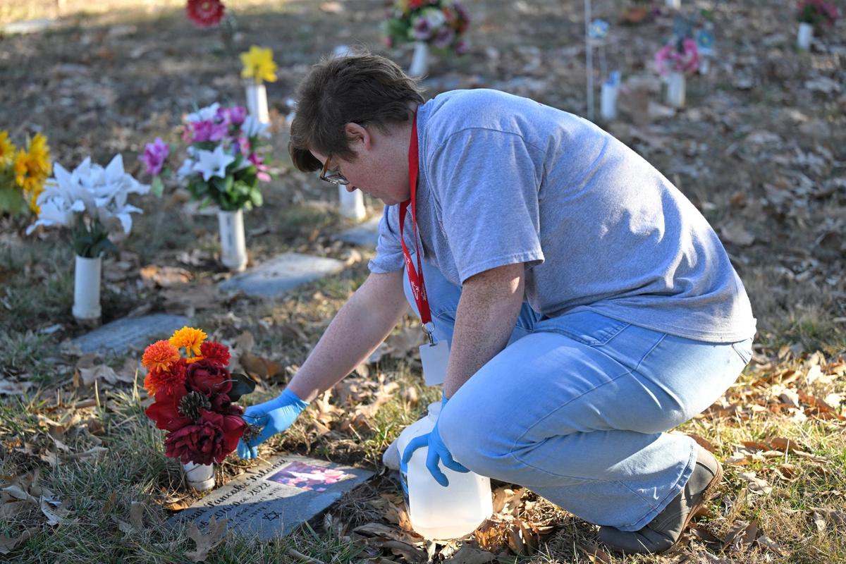 Laura Keyworth, Wayside’s pet memorial services manager, removes leaves before cleaning a headstone for a cockatiel.