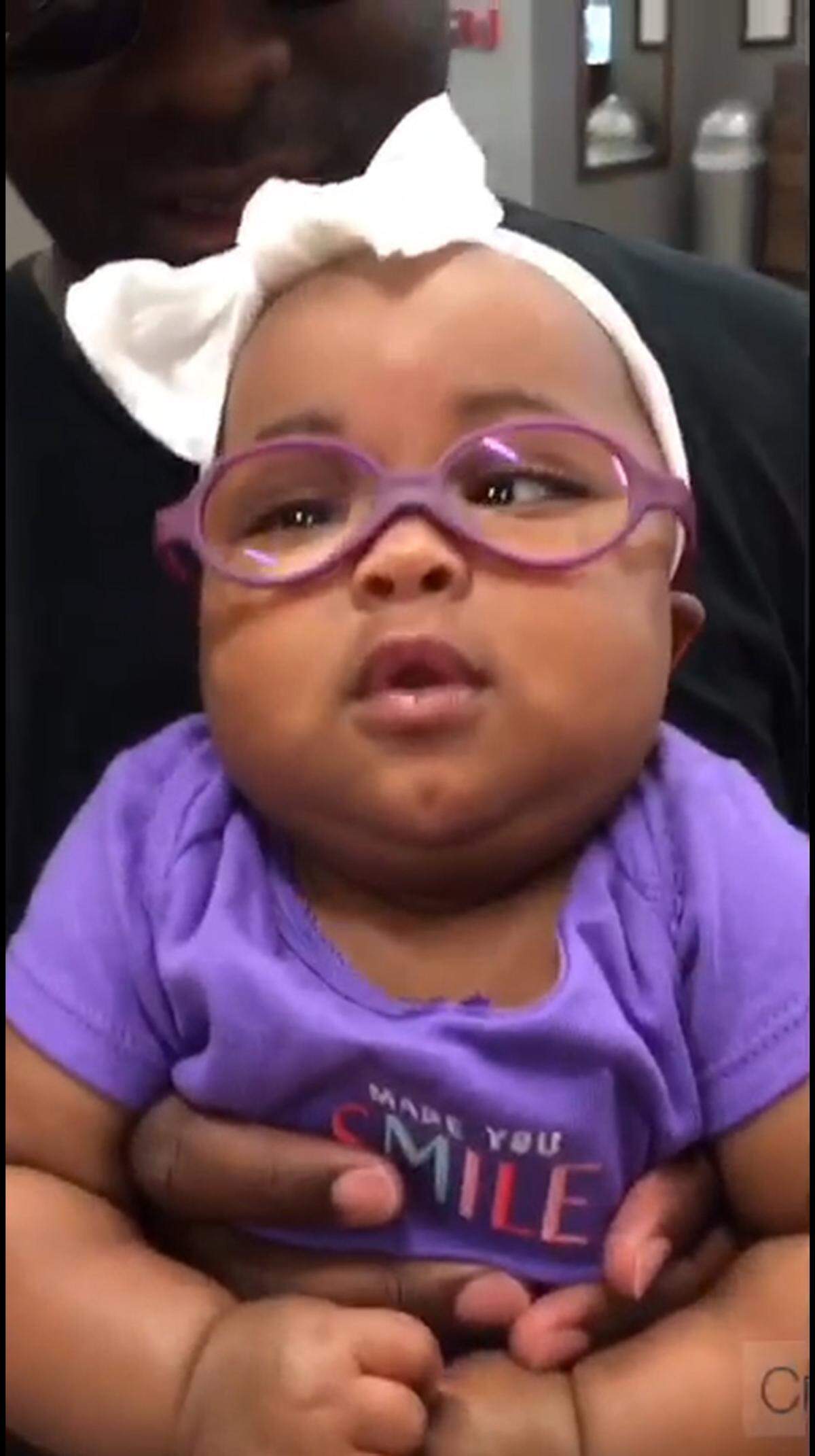 Juliana McBride, at 10 months, looked around with her new glasses that allowed her to see her father clearly for the first time.