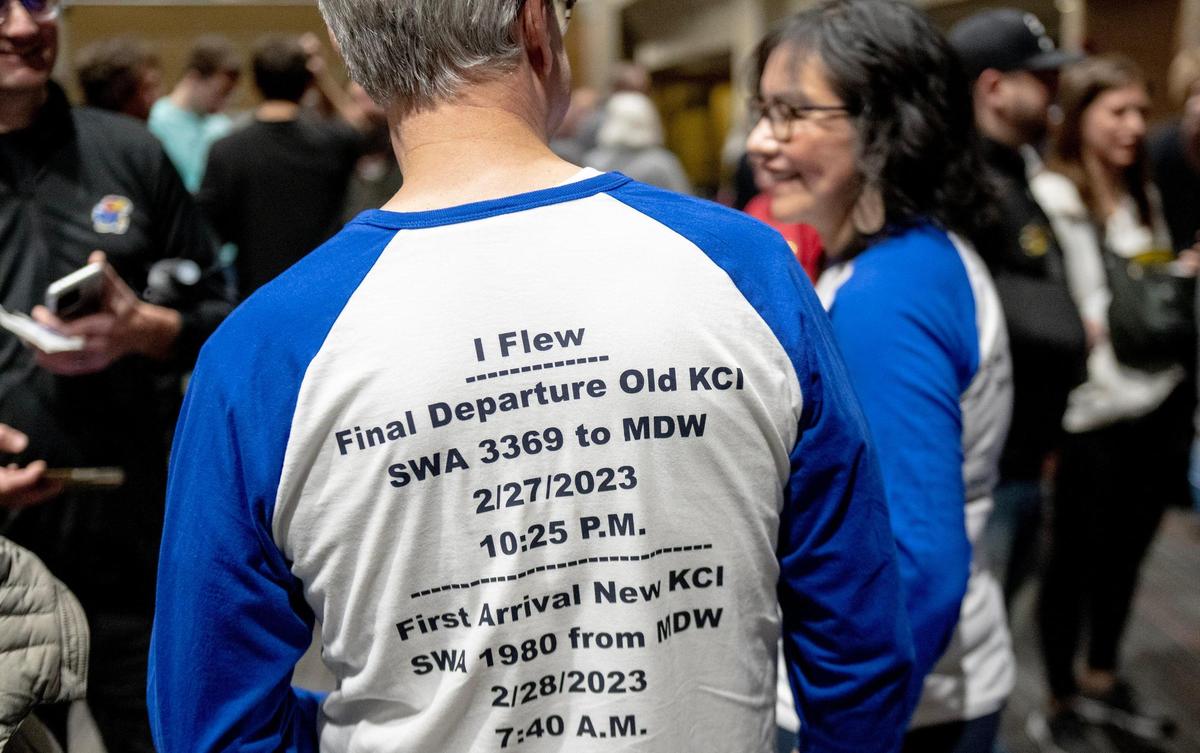 Jere and Veronica Sellers wear custom shirts to mark the occasion of being onboard both the final flight out of KCI’s old terminals and the first flight scheduled to arrive to the new terminal on Monday, Feb. 27, 2023, in Kansas City.