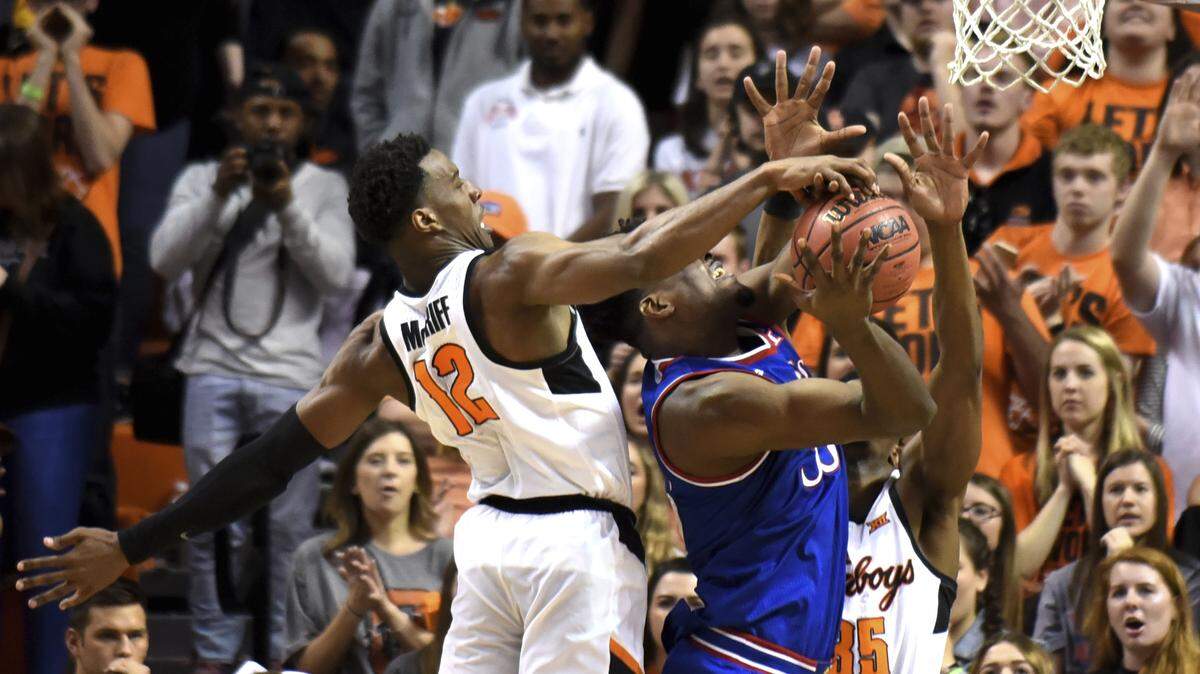 Kansas center Udoka Azubuike had his shot blocked by Oklahoma State's Cameron McGriff (left) and Yankuba Sima in the first half of Saturday's game.