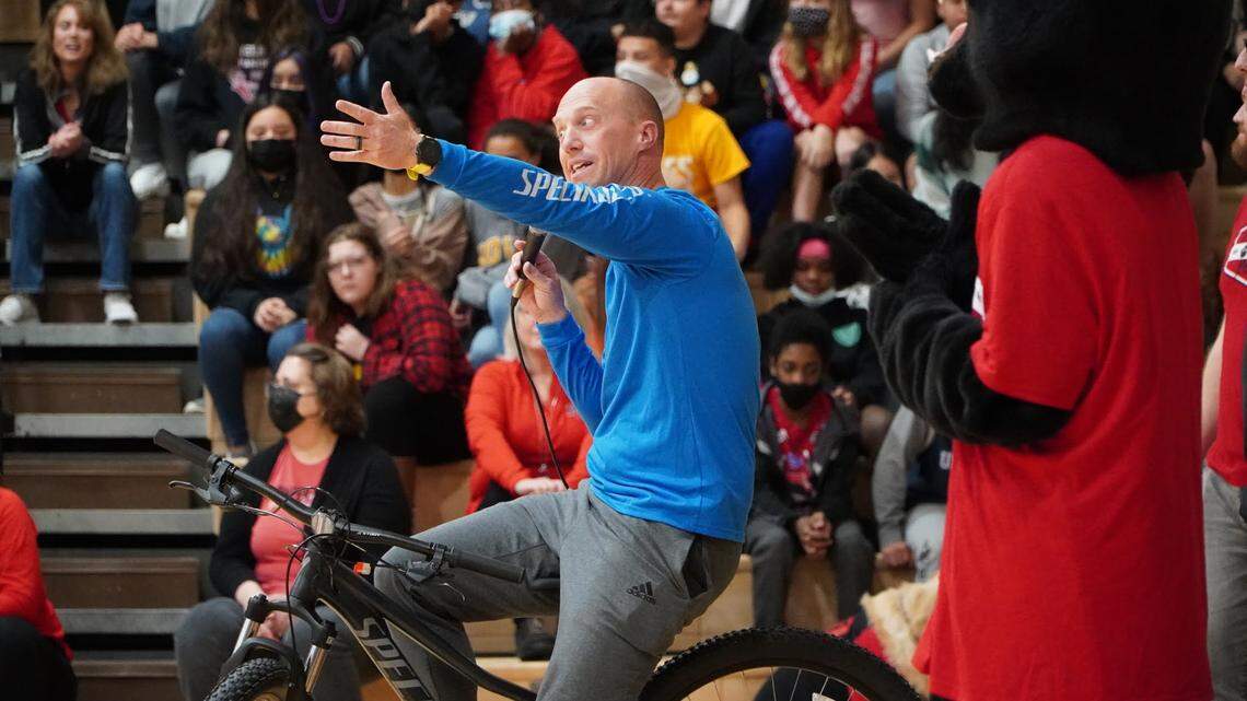 Adaptive physical education teacher Brandon Simpson shows kids at Pioneer Trail Middle School the kind of bike they’ll get to ride in gym class as part of a new grant-supported program.