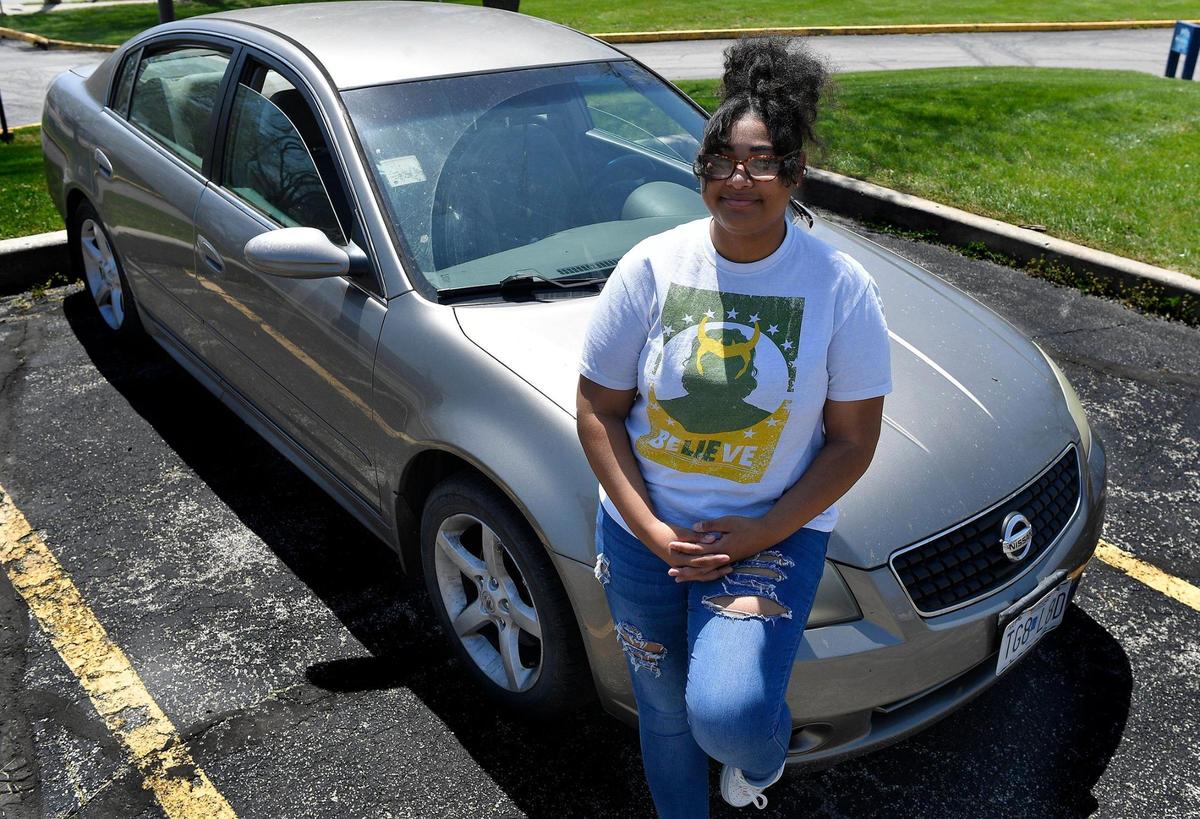 Jayla Johnson is pictured with her 2006 Nissan Altima, which was damaged in April by a Kansas City pothole. Johnson had to replace the right front wheel and tire.