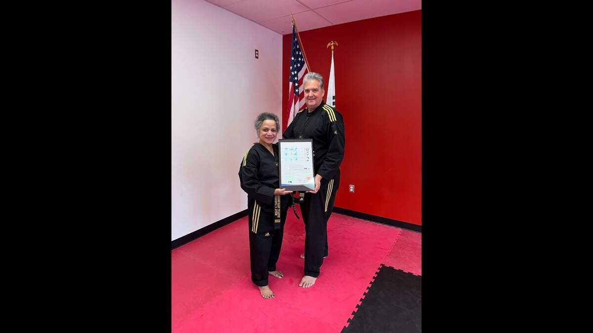 Molly Varghese receives her black belt certificate from David Popper, master instructor/owner at Martial Arts Institute North in Overland Park.