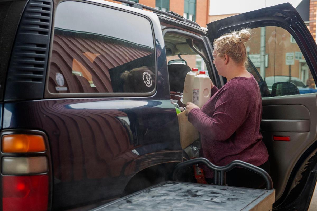 Taylor Huff loads into her car a box of food, toiletries and clothing that she received from Open Door food pantry in Sedalia on Dec. 7, 2021.