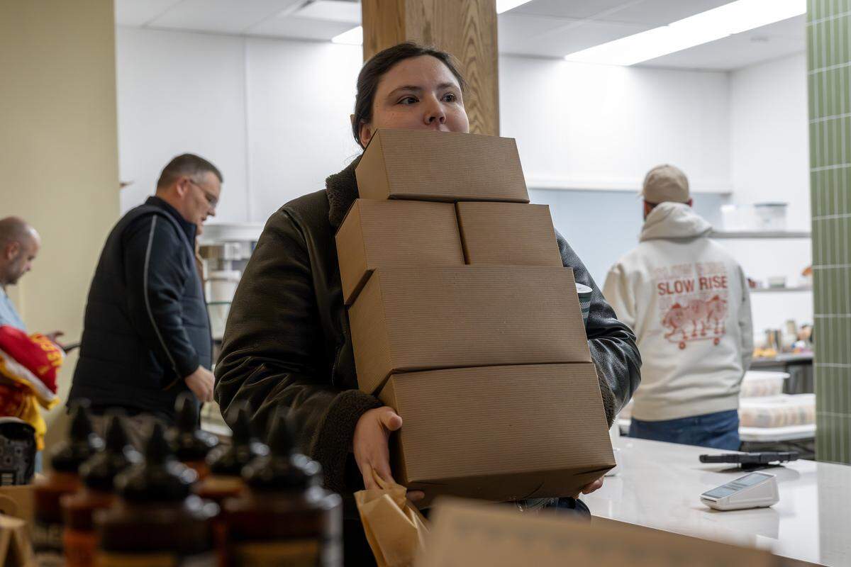 A customer exits Slow Rise carrying boxes of doughnuts during the shop's soft opening on Friday, Jan. 23, 2026, in Overland Park.