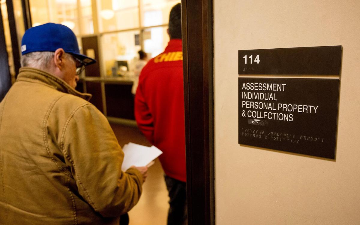 People wait to work with staff at the Jackson County Assessment office on Friday, March 29, 2024, in Independence, Missouri.
