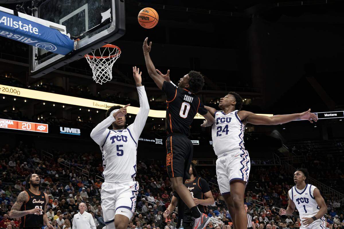 Oklahoma State Cowboys guard Jaylen Curry (0) goes for two as Texas Christian University Horned Frogs forward Micah Robinson (5) and Texas Christian University Horned Frogs forward Xavier Edmonds (24) defend during the first half of the Big 12 Men's Basketball Tournament at T-Mobile Center on Wednesday, March 11, 2026, in Kansas City.