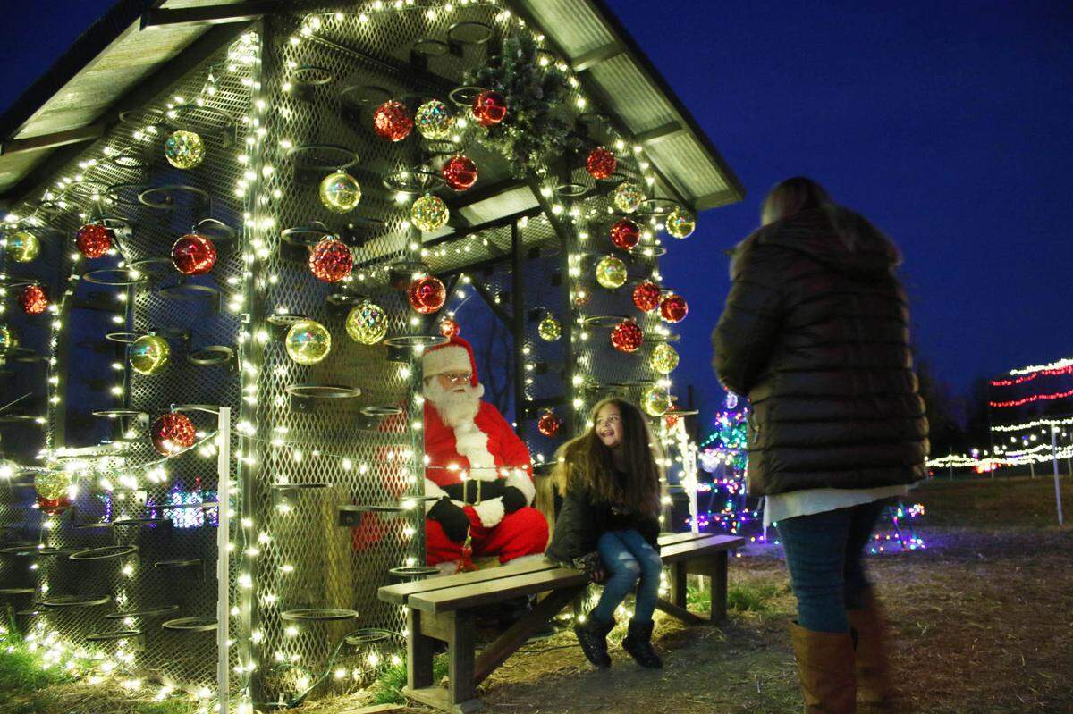 Olathe resident LaMia Strong has a visit with Santa Claus as Lindsey Strong snaps a photo at an Olathe holiday event in 2021.