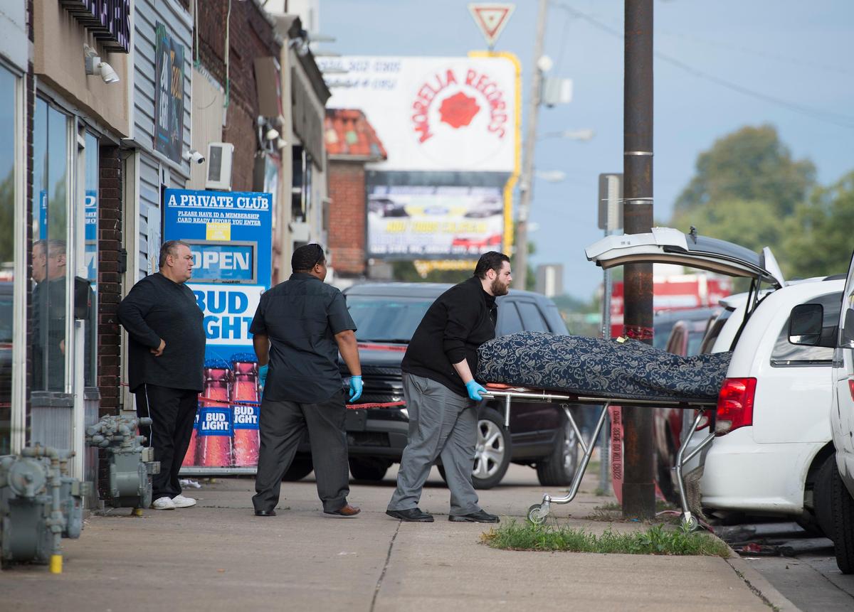 The body of one of four shooting victims was removed Sunday from Tequila KC in Kansas City, Kansas. Police said two gunmen entered the bar early Sunday and shot nine people, killing four of them.