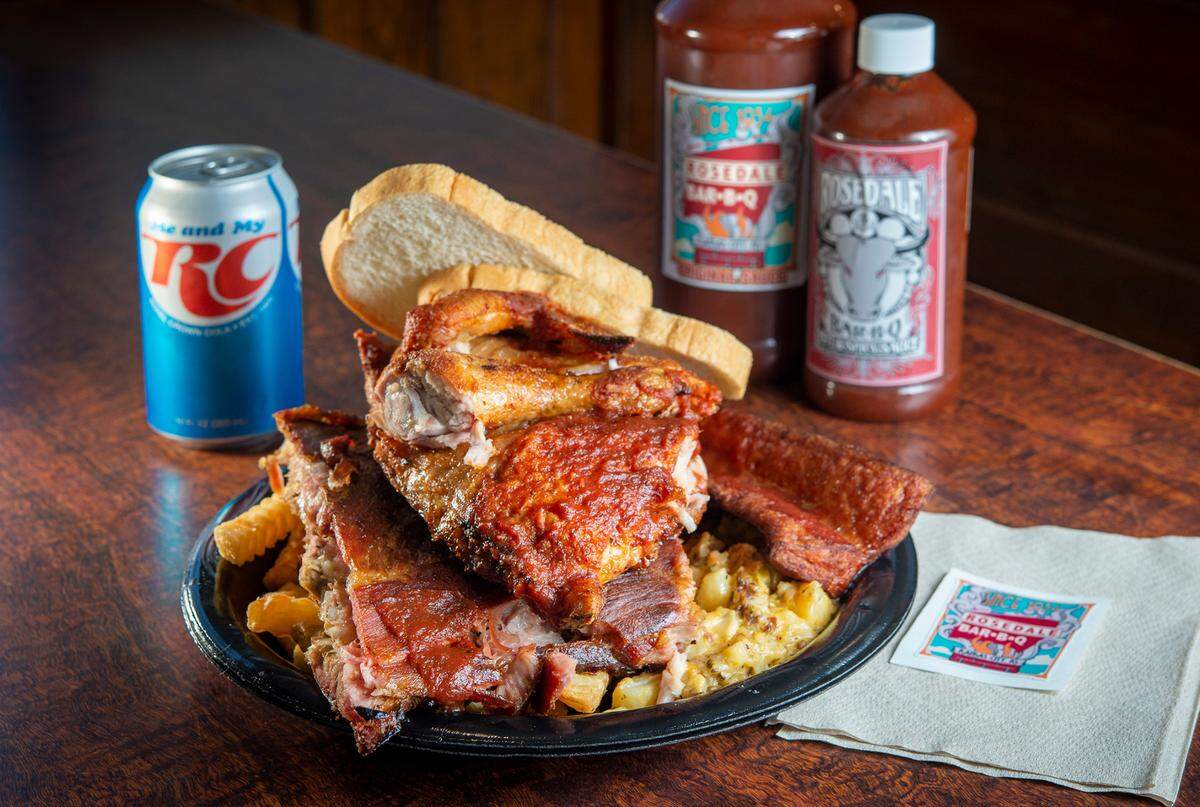 Rosedale Bar-B-Q’s Flying Pig dinner includes half a barbecue chicken and three ribs. Sides include sausage, right, fries and beans. 