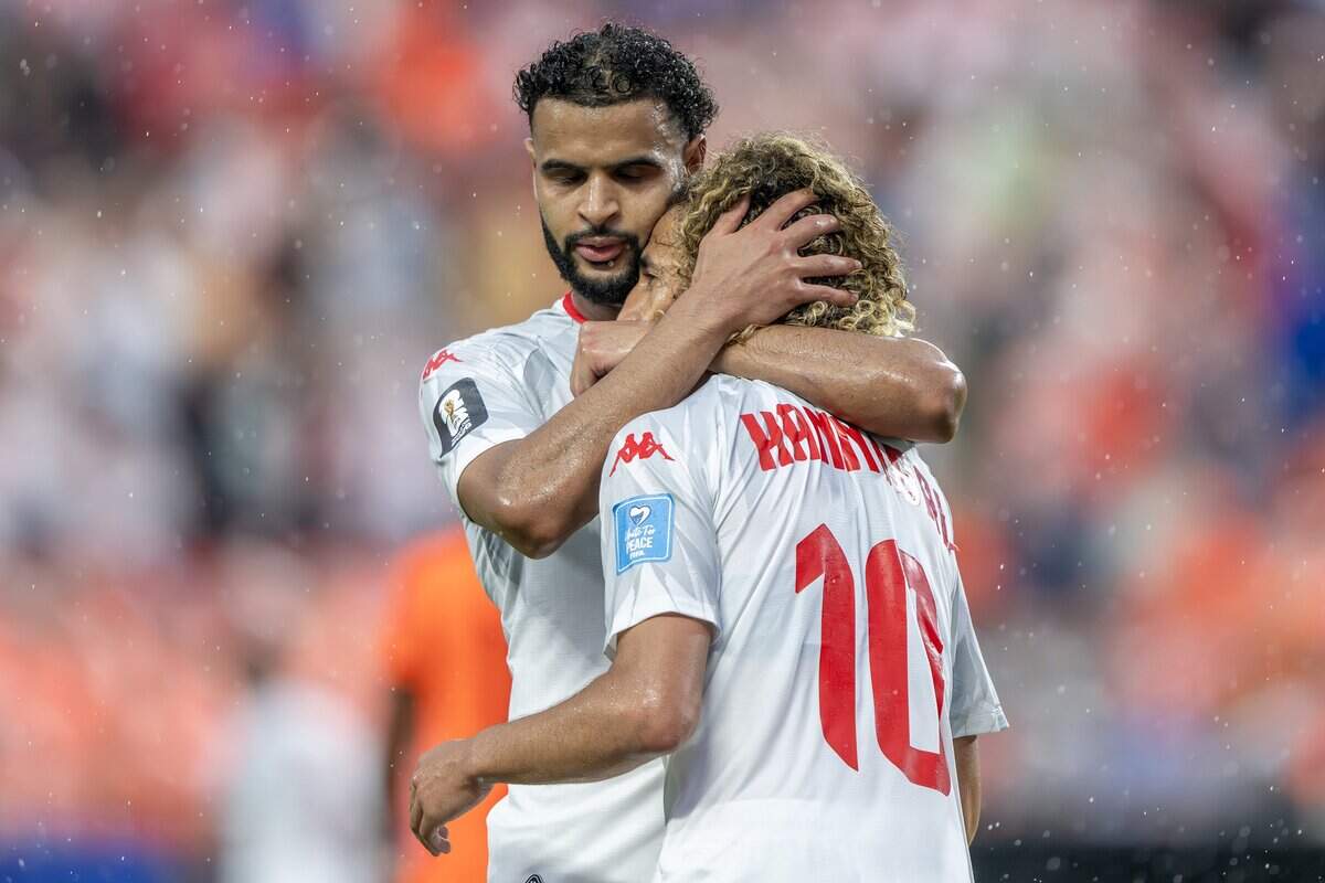 Tunisia midfielders Anis Ben Slimane (25) and Hannibal Mejbri (10) embrace after Slimane scored on a corner kick by Mejbri during the second half of a FIFA World Cup group-stage soccer match against the Netherlands at Kansas City Stadium on Thursday, June 25, 2026.