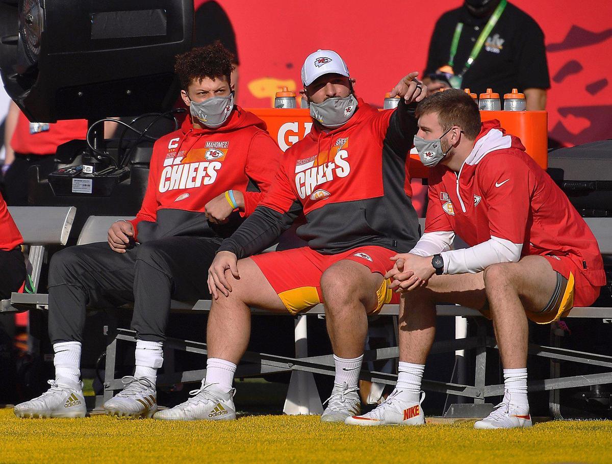 Kansas City Chiefs quarterback Patrick Mahomes, left, sits on the bench with staff and teammates Sunday, February 7, 2021, before Super Bowl LV at Raymond James Stadium in Tampa, Florida.