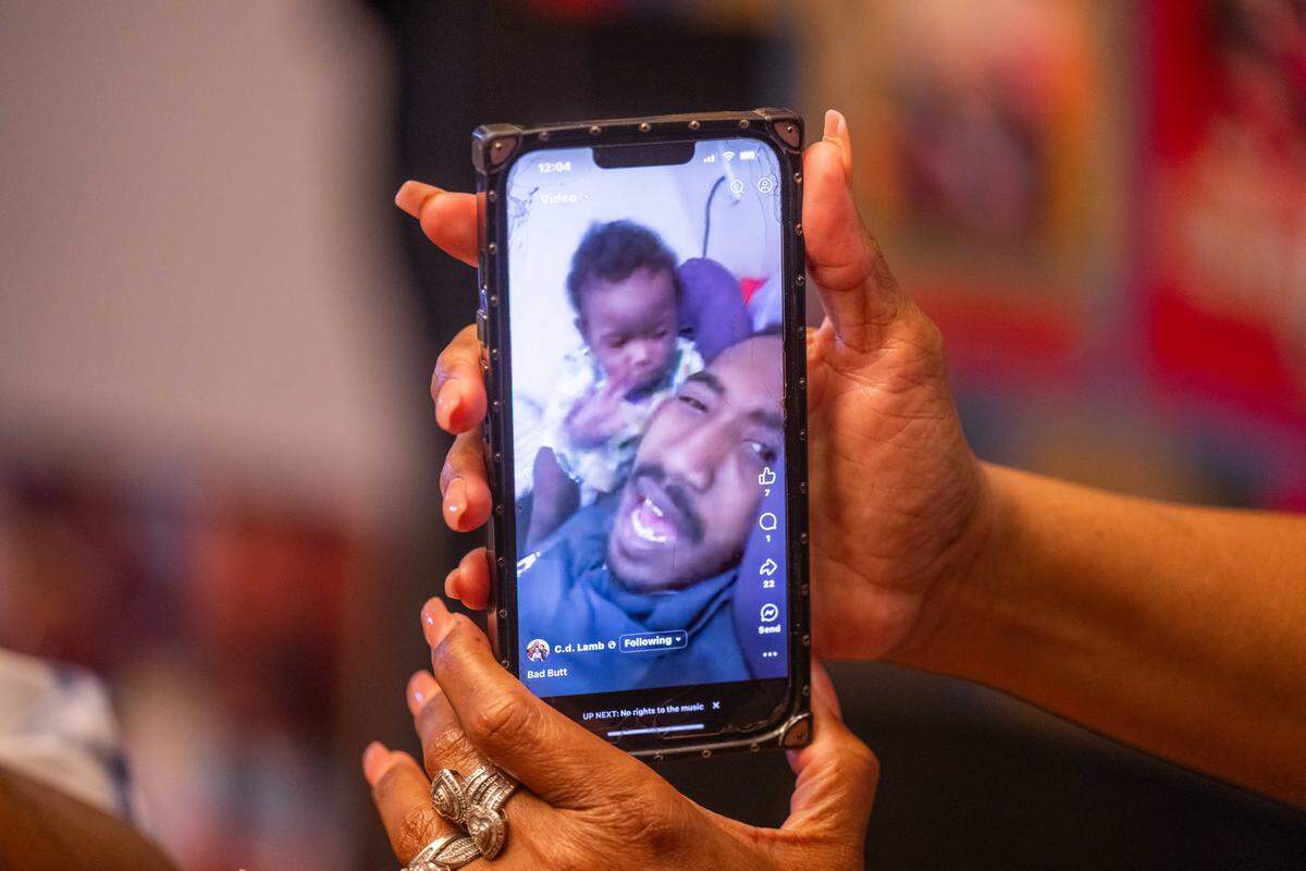 A video of Cameron Lamb and his son plays on the phone of Laurie Bey, Lamb’s mother, at her home in Kansas City on July 21. Lamb’s three sons are now 6, 10, and 12.&nbsp;