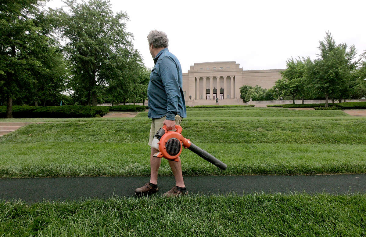 James Throckmorton carries his leaf blower between holes as he maintains the Art Course at the Nelson-Atkins Museum of Art.