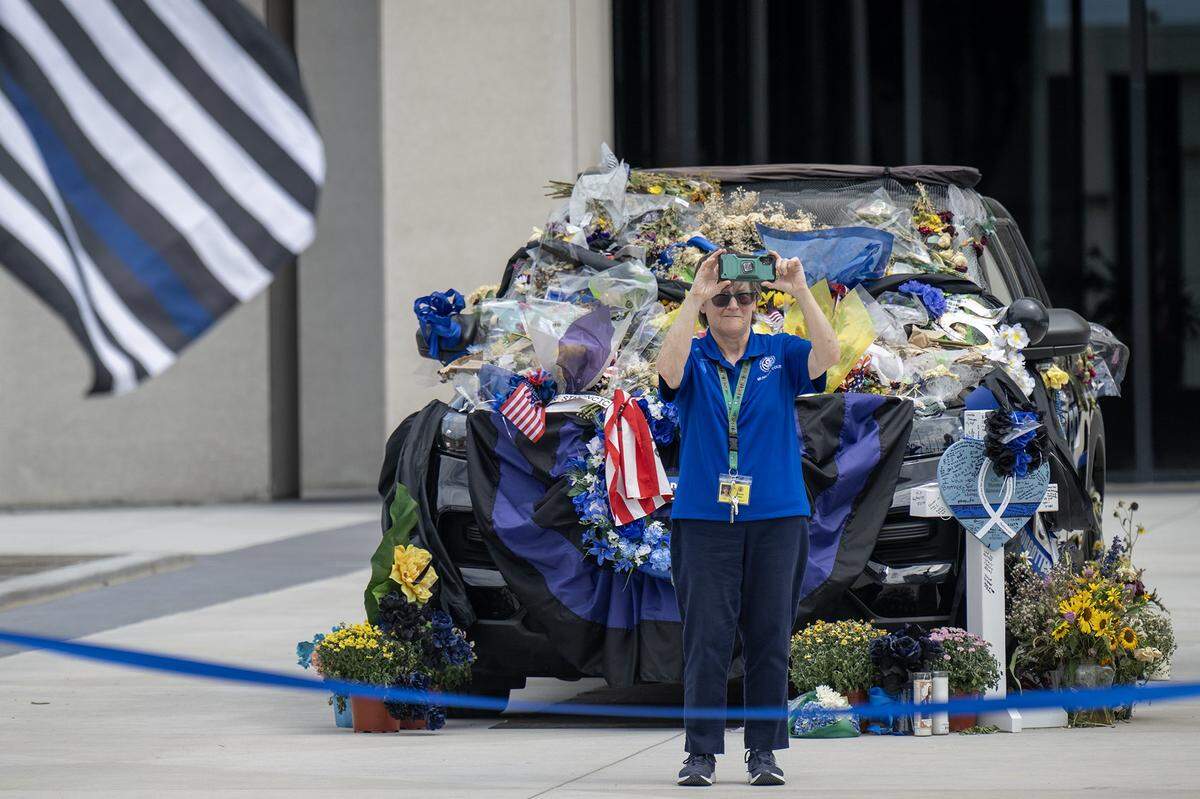Kathleen Holton took photos as the procession for Kansas City, Kansas, police officer Hunter Simoncic traveled through downtown Kansas City, Kansas, on Wednesday, Sept. 3, 2025. Simoncic's patrol vehicle was on display during the procession.