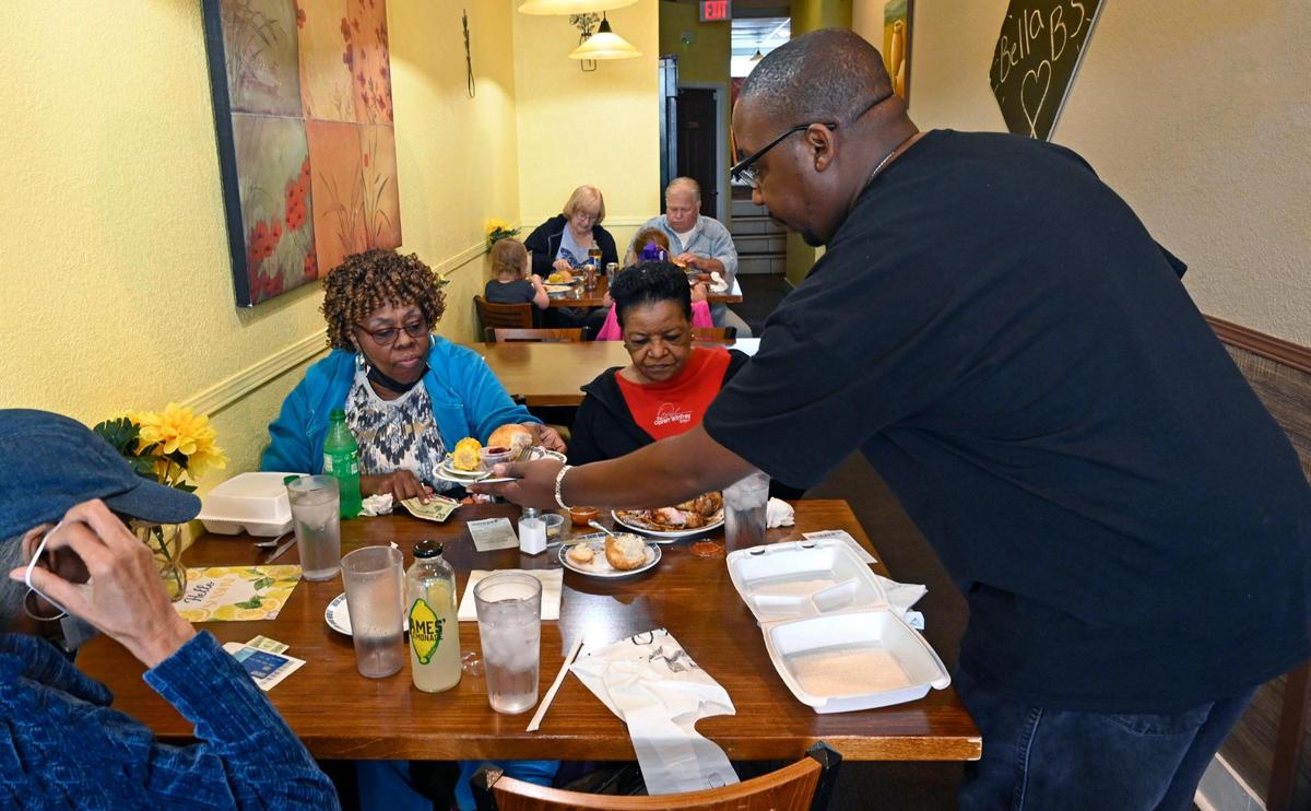 Demonte Rochester, a co-owner of Bella B’s Kitchen, 6225 Blue Ridge Blvd., in Raytown, attends to diners during lunch.