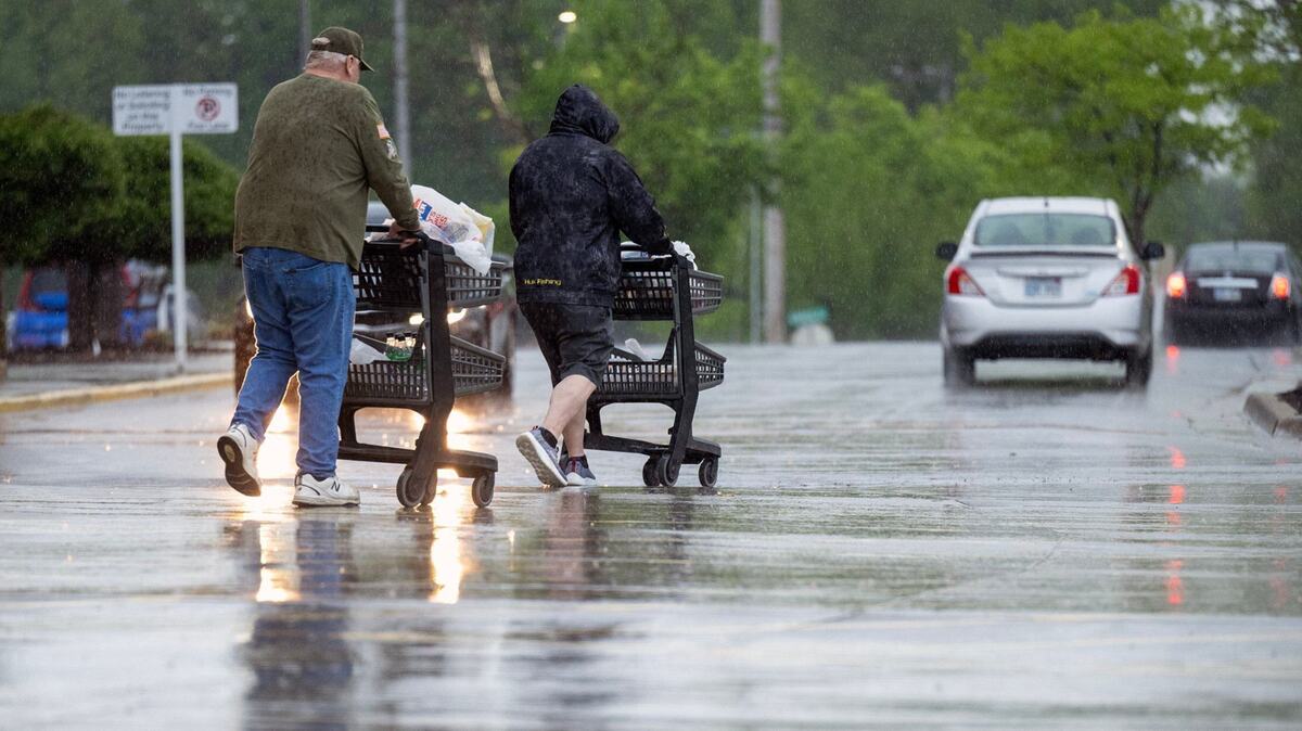 Shoppers leave a Kansas City area grocery store in heavy rain in April 2024. Easter 2025 is expected to be rainy.