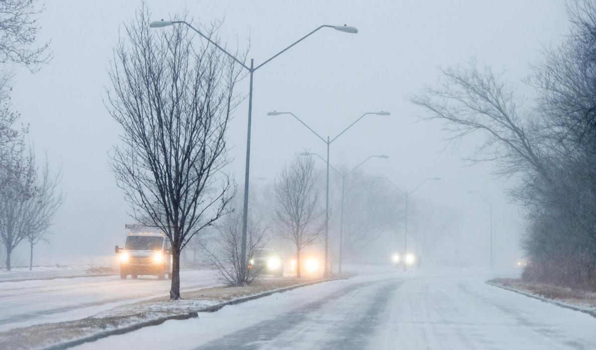 Vehicles travel along Broadway Boulevard as snow falls on Thursday, Dec. 22, 2022, in Kansas City.