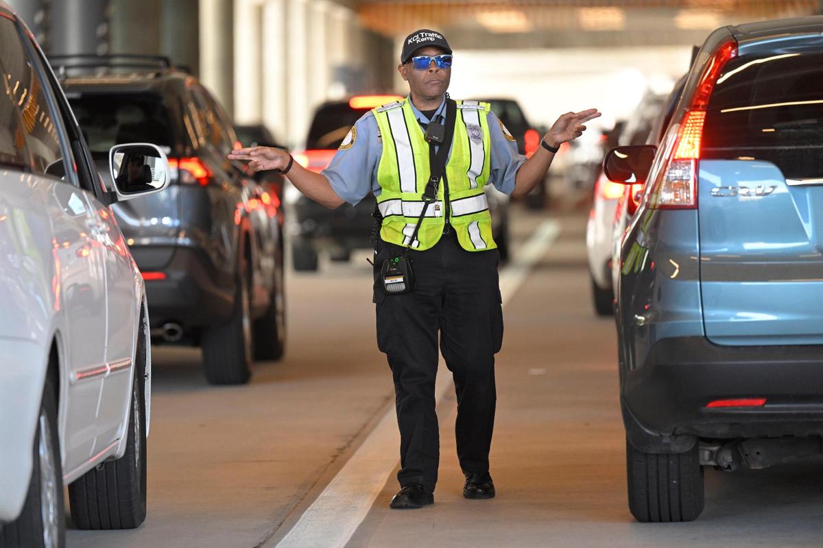Clyde Kemp Jr., a traffic control officer, directs traffic as cars arrive Friday, April 21, 2023, to pick up passengers at Kansas City International Airport.