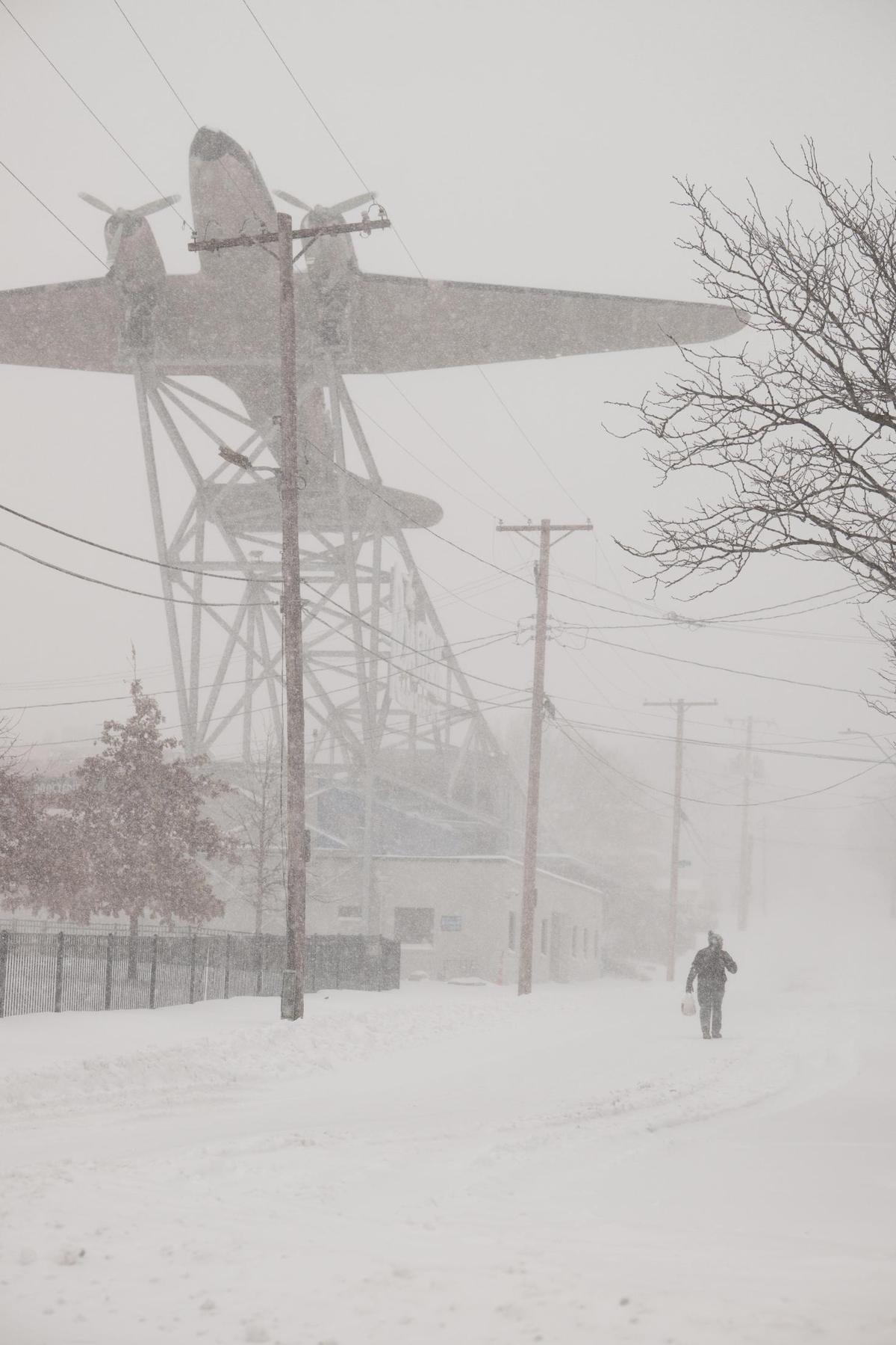 A person walks near the Roasterie Coffee shop during heavy snowfall on Sunday. Kansas City saw over five inches of snow fall in a matter of hours on Sunday, Jan. 5, 2025. Travel routes were heavily impacted with some people opting to travel by foot.