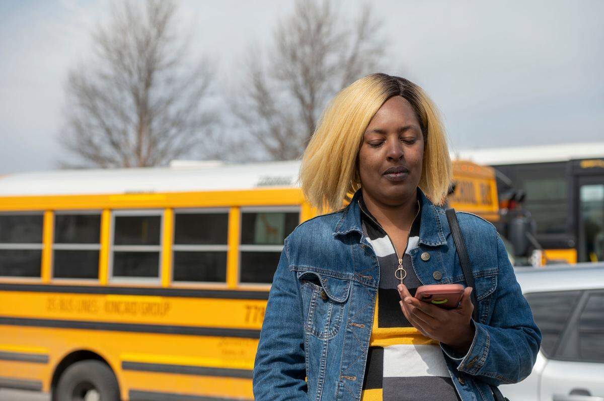 Keicia Stillman speaks to her daughter over the phone as she waits to be reunited with her after a shooting Friday at Olathe East High School. 
