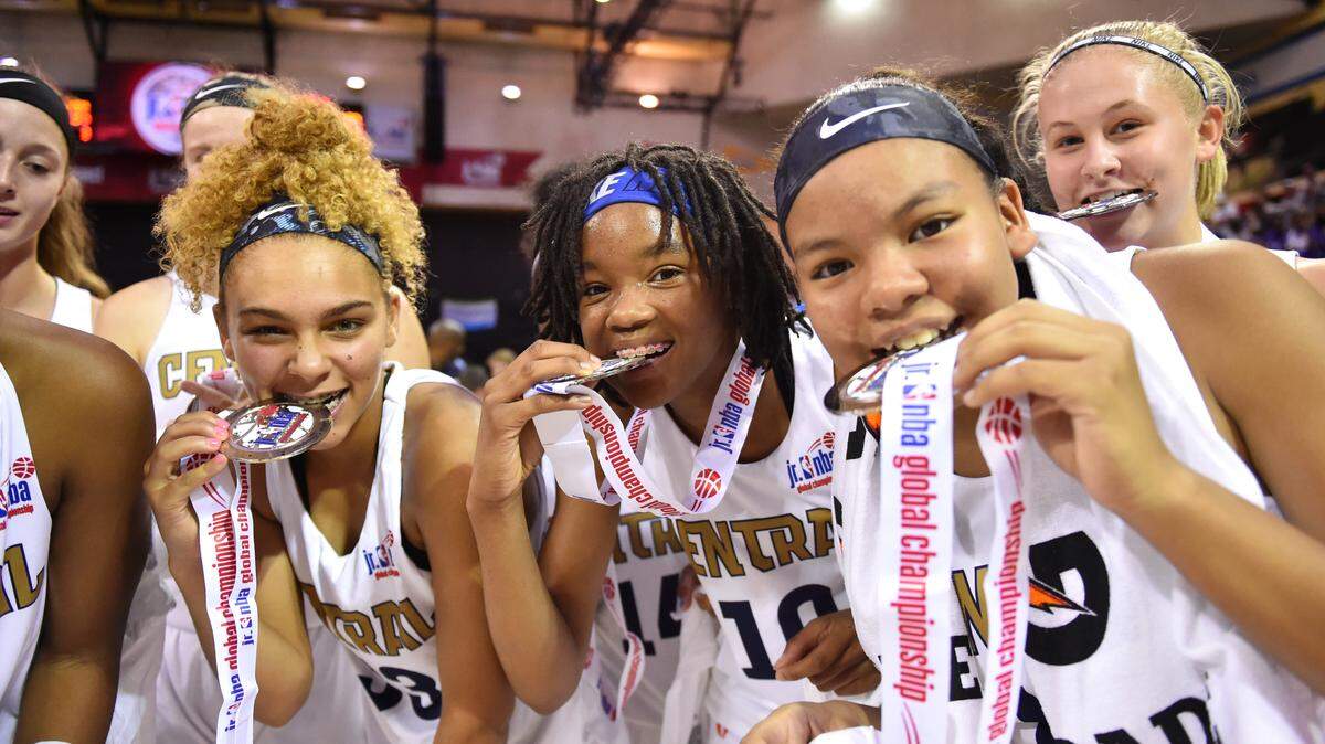 Members of the U.S. Central girls basketball team celebrate with their medals after beating Canada for the Jr. NBA Girls Global Championship Sunday in Orlando.
