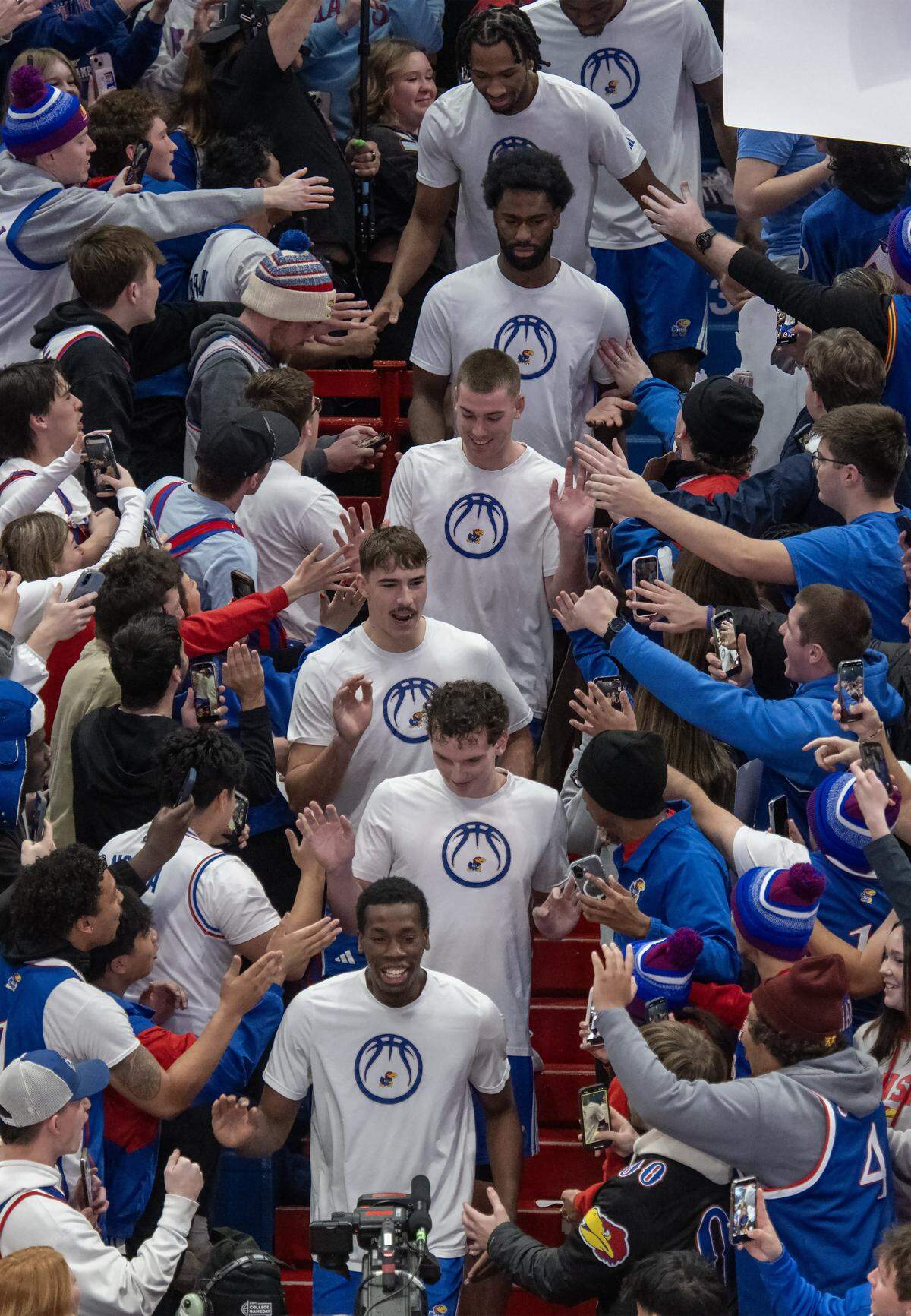 Members of the Kansas Jayhawks basketball team walk through the stands during ESPN College Gameday at Allen Fieldhouse on Saturday, Jan. 31, 2026, in Lawrence.