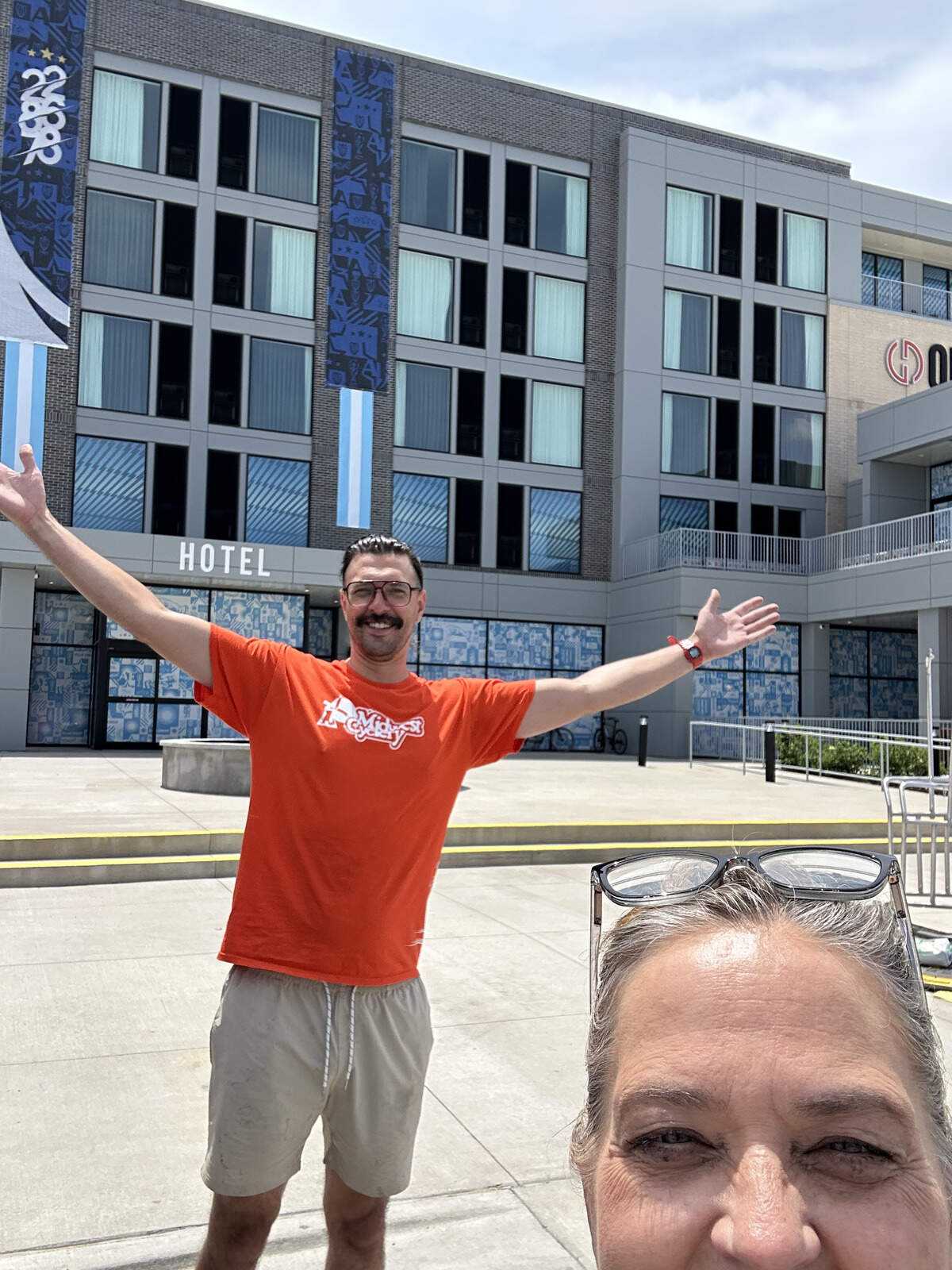 Christina Baanders-Decker and her employee, Pat, take a picture in front of Origin Hotel after delivering bikes for members of the Argentina team.