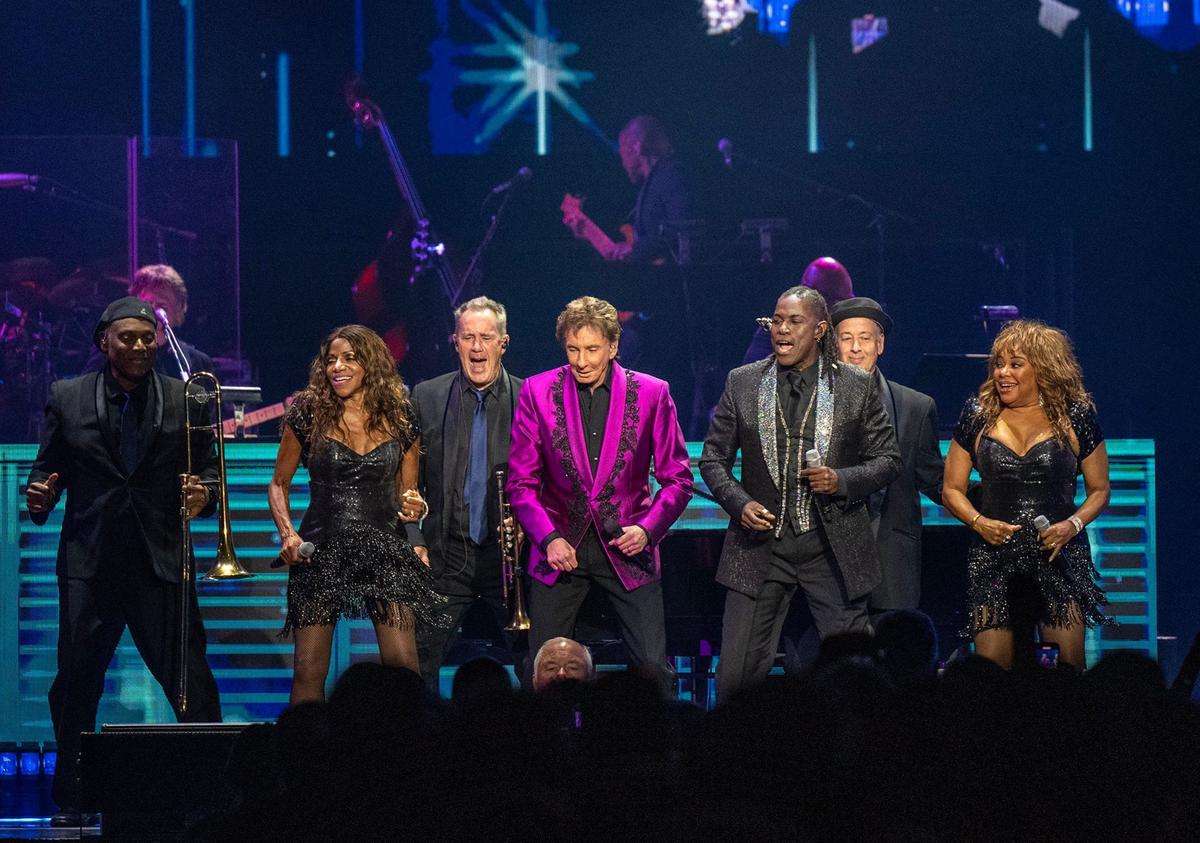 Barry Manilow sings and dances across the stage with his ensemble at the T-Mobile Center on Sunday.
