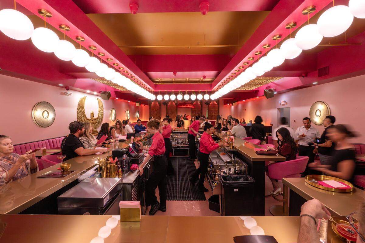 People are seen at the bar and booths inside Laila Lounge, where pink walls and gold accents cover the space, on Friday, Aug. 8, 2025, in Kansas City.
