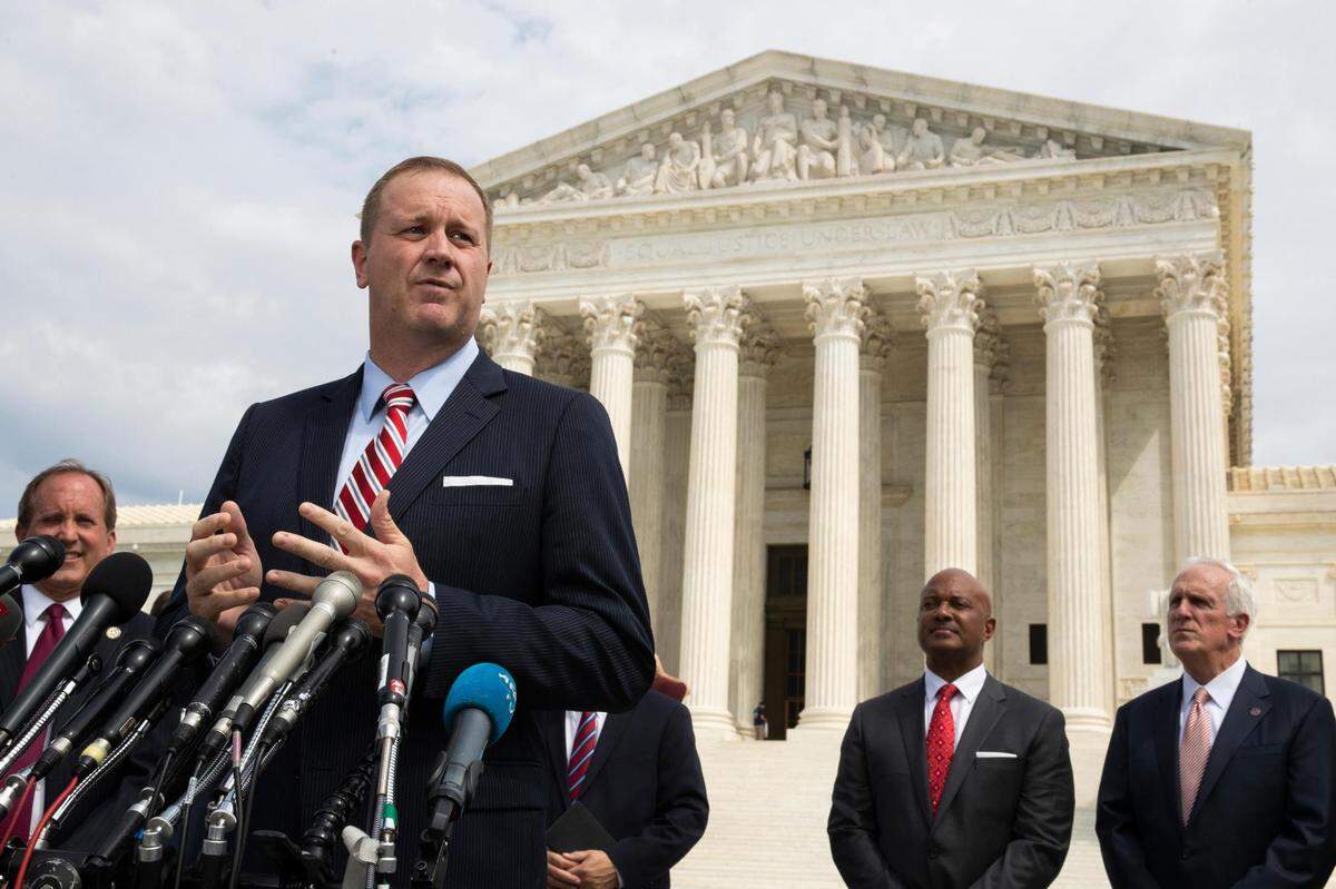 In this Sept. 9, 2019, file photo, Missouri Attorney General Eric Schmitt speaks in front of the U.S. Supreme Court in Washington. Schmitt on Tuesday, April 21, 2020, filed a lawsuit against the Chinese government, the Community Party of China and others, alleging that the hiding of information and other actions at the outset of the coronavirus outbreak led to loss of life and significant economic damage in Missouri.