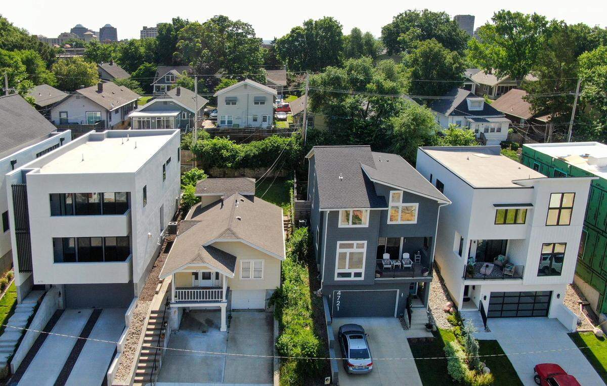A traditional bungalow-style home built in 1925 is sandwiched between newly constructed, modern, multi-story homes in the 4700 block of Liberty Street in the West Plaza neighborhood of Kansas City.