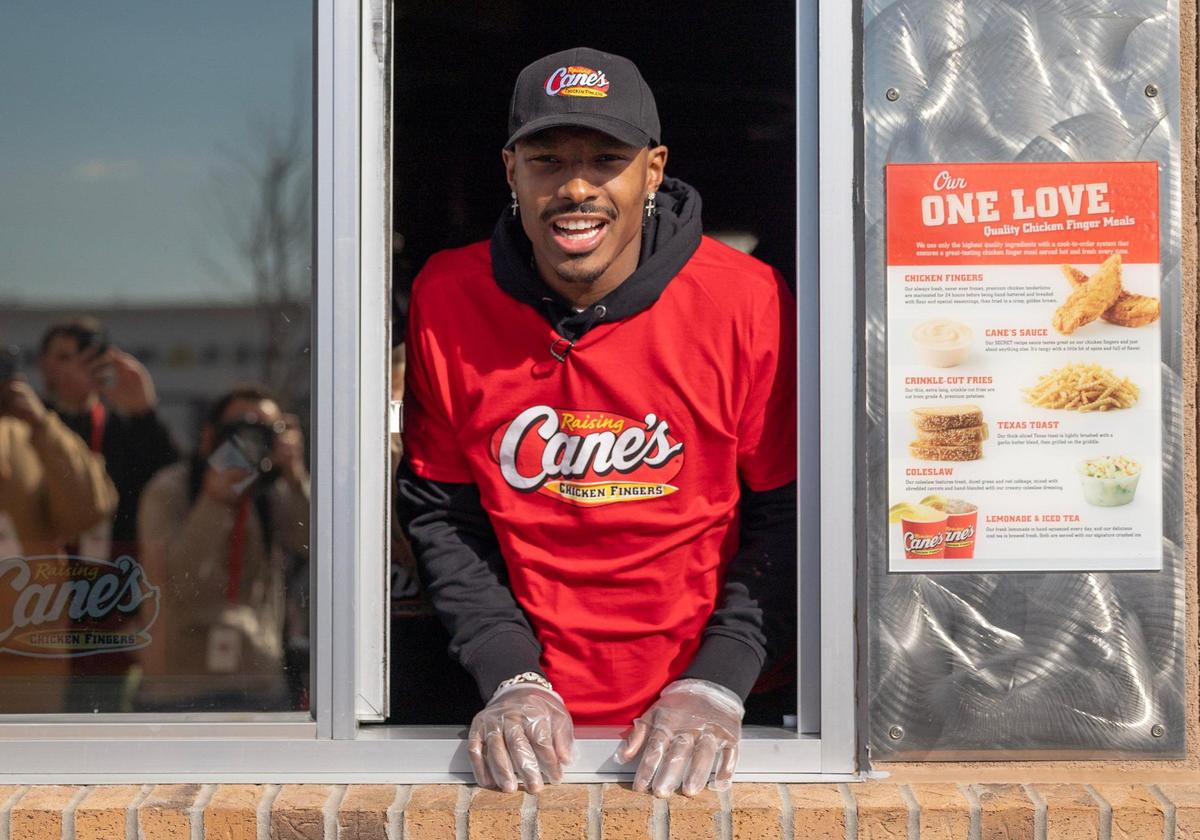 Kansas City Chiefs receiver Mecole Hardman Jr. takes a look out the drive through window while working at a Raising Cane’s restaurant in Blue Springs on Tuesday. Hardman was joined by teammate L’Jarius Sneed at the event.