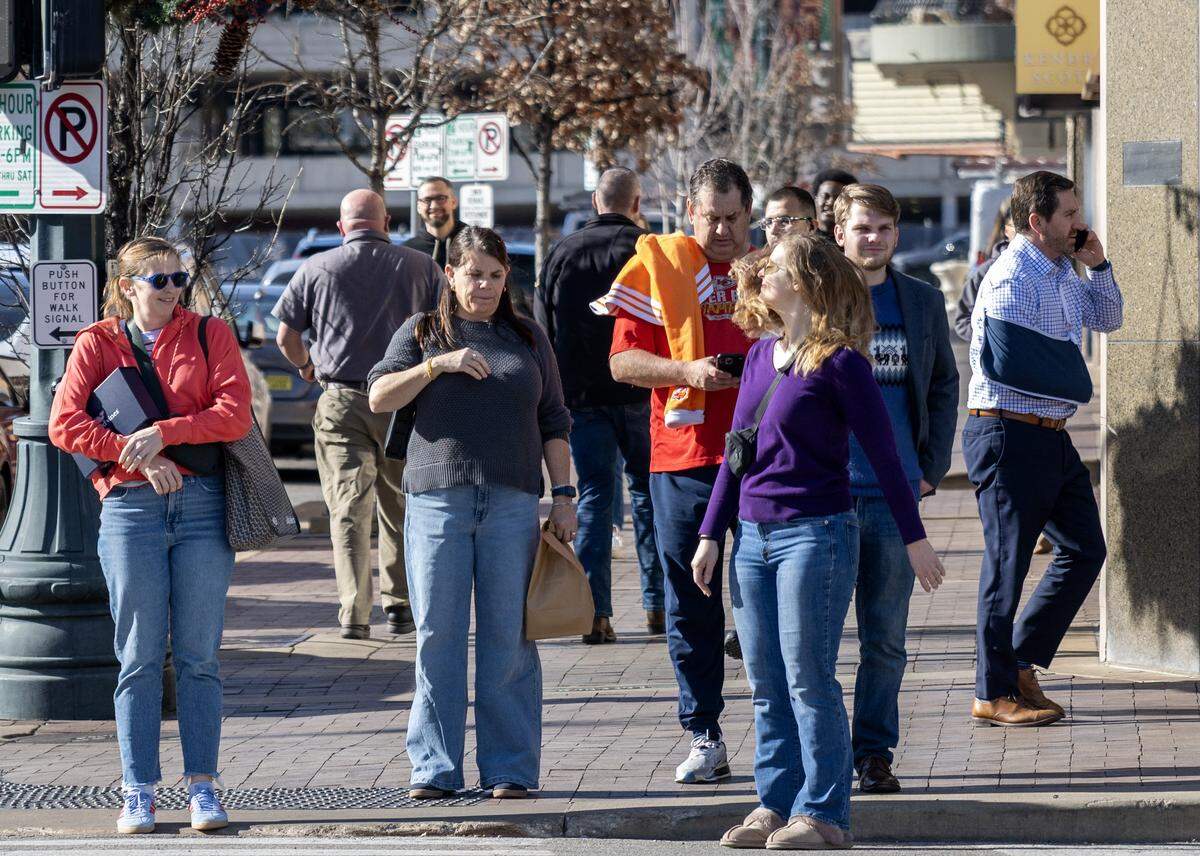Pedestrians wait to cross Pennsylvania Avenue along Nichols Road at the Country Club Plaza on Tuesday, Dec. 16, 2025, in Kansas City.