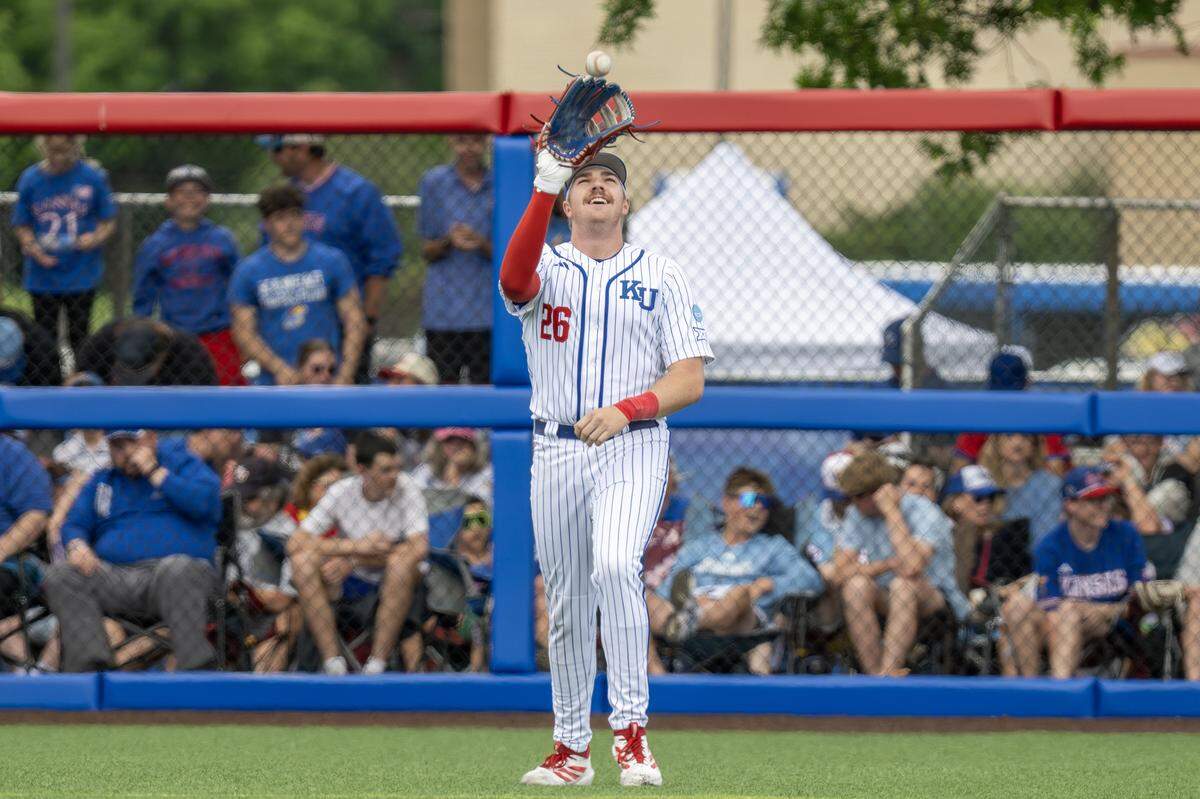 Kansas Jayhawks utility Brady Ballinger (26) warms up before the bottom of the seventh inning against the Northeastern Huskies during an NCAA baseball tournament game at Hoglund Ballpark on Friday, May 29, 2026, in Lawrence.
