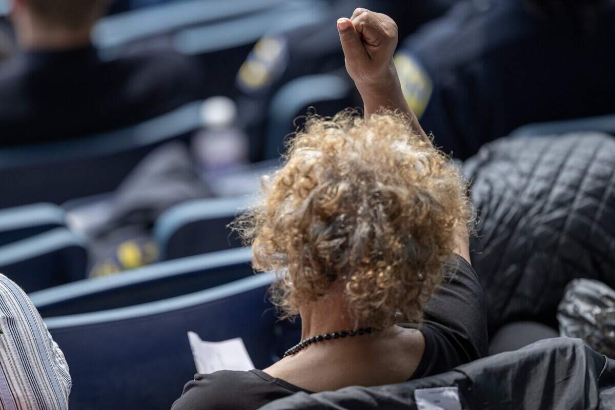 An attendee raises a fist during a prayer song during the memorial for Deputy Elijah Ming at Children's Mercy Park on Monday, Aug. 11, 2025, in Kansas City, Kansas.