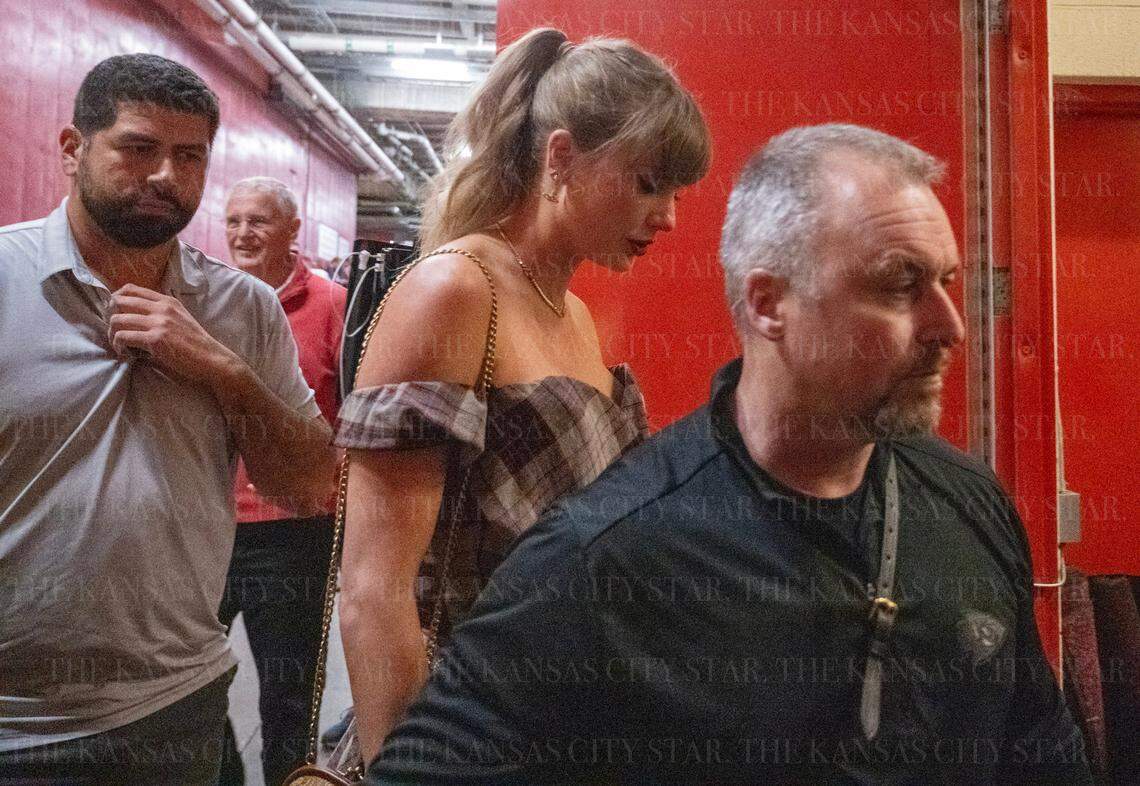 Taylor Swift, seen here arriving with her security posse, and her dad, Scott Swift (in the back, in red), watched the Chiefs-Saints game together at GEHA Field at Arrowhead Stadium Monday night.