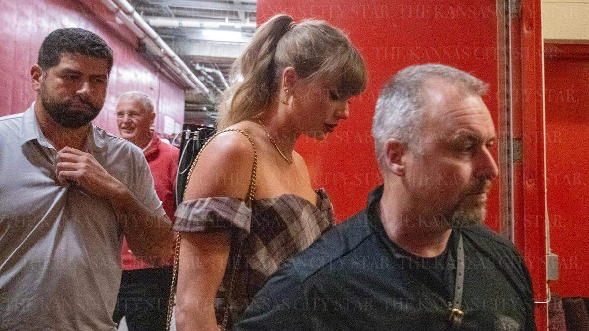 Taylor Swift, seen here arriving with her security posse, and her dad, Scott Swift (in the back, in red), watched the Chiefs-Saints game together at GEHA Field at Arrowhead Stadium Monday night.